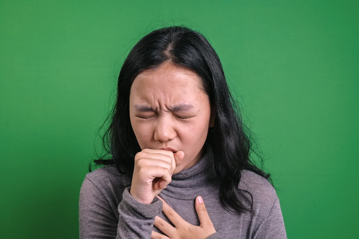 Une personne qui tousse en se tenant la poitrine